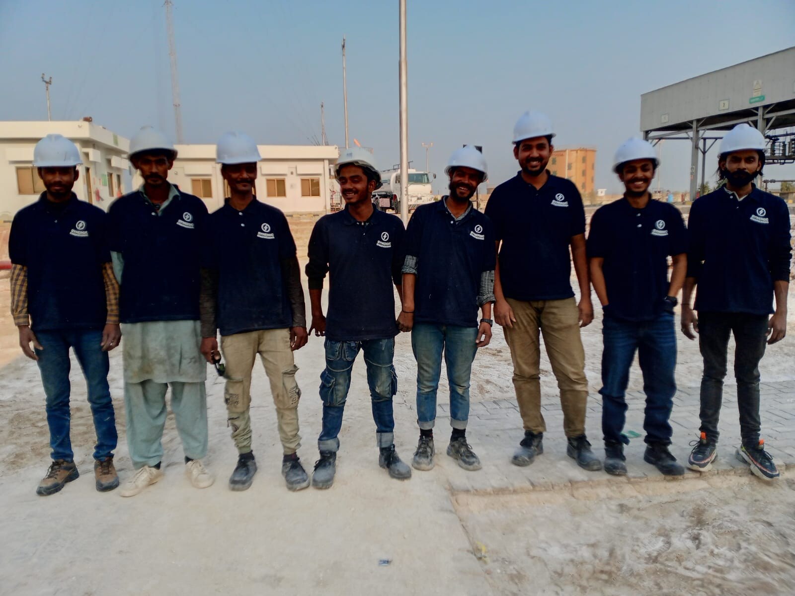 Engineering team standing together at an outdoor industrial site
