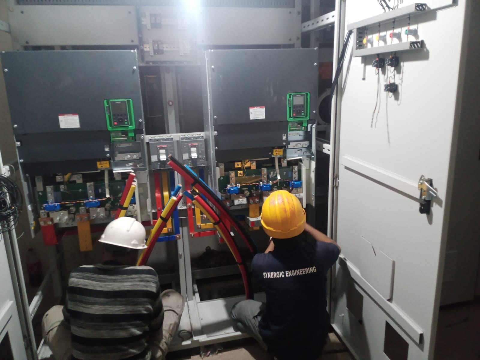 Technicians working at an electrical panel